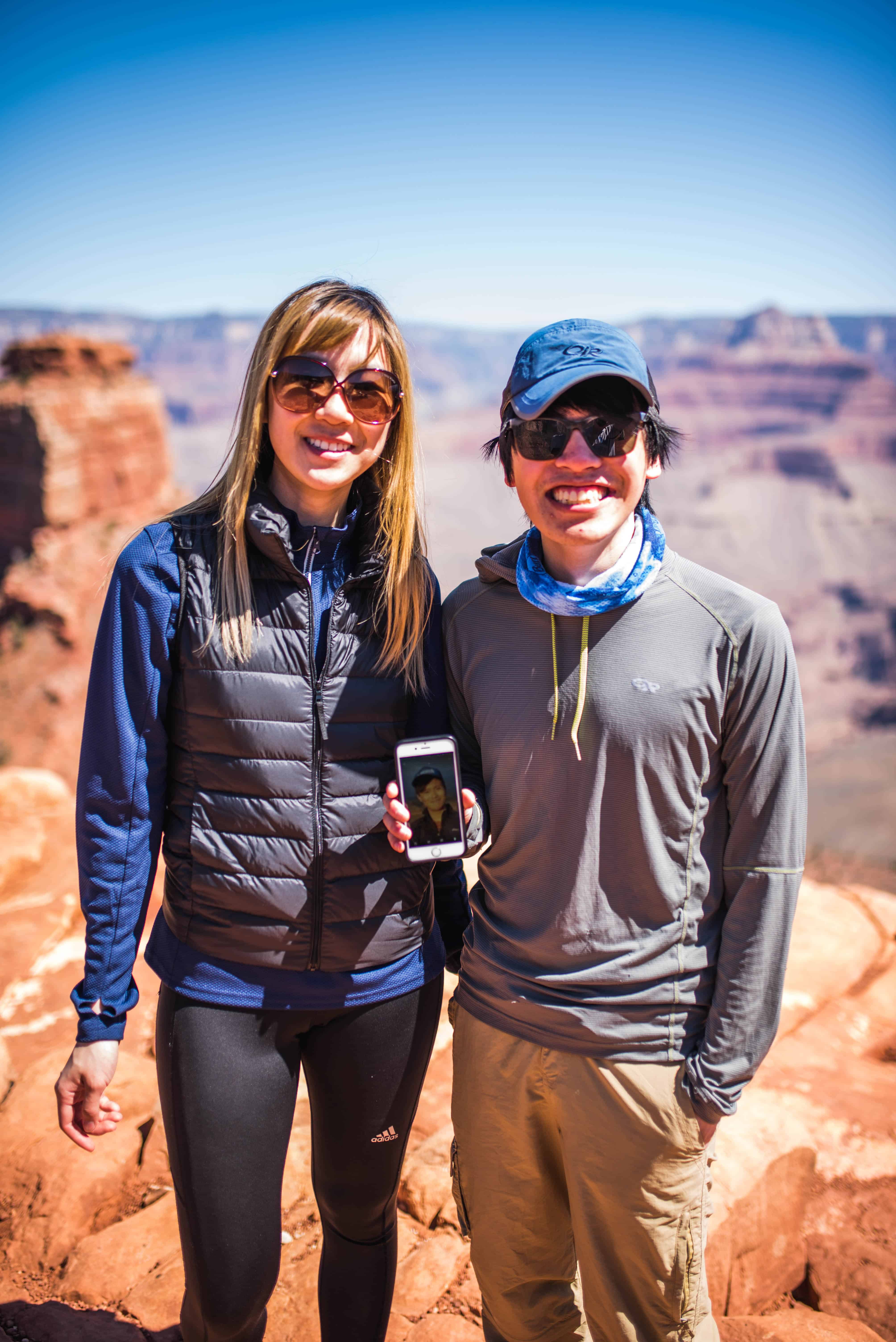 Maria and Anson holding a photo of Kent posing in front of the Grand Canyon