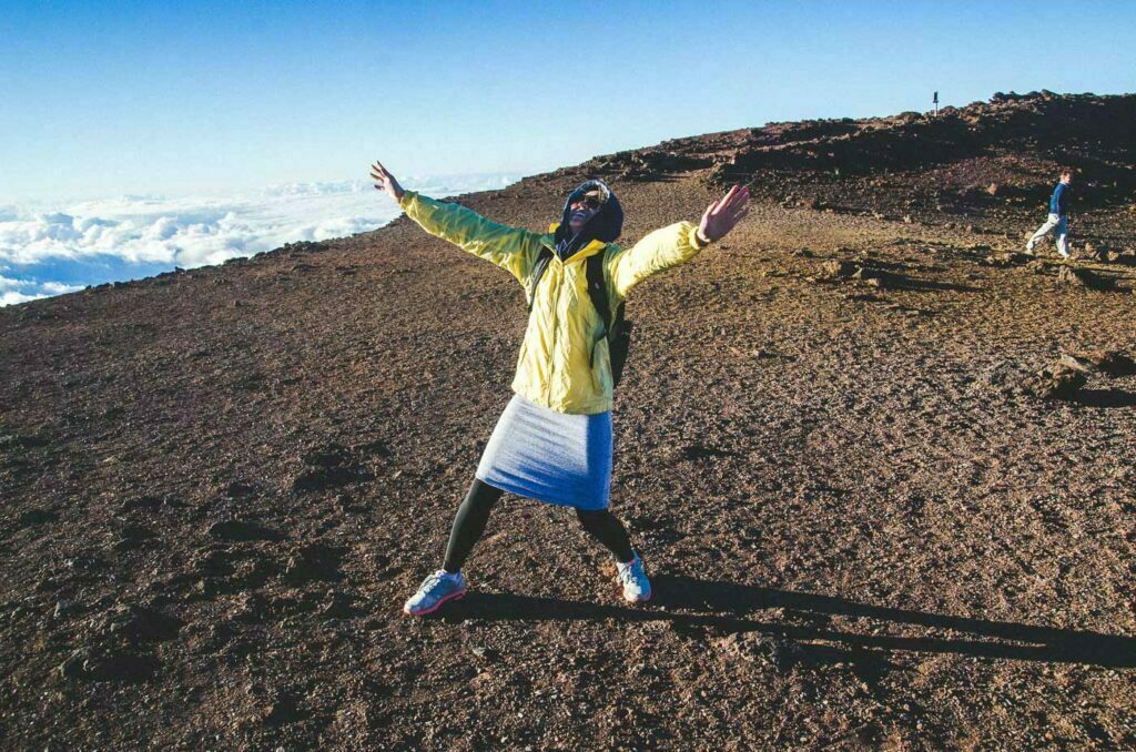 Woman holding arms outstretched the fight the wind atop Haleakala