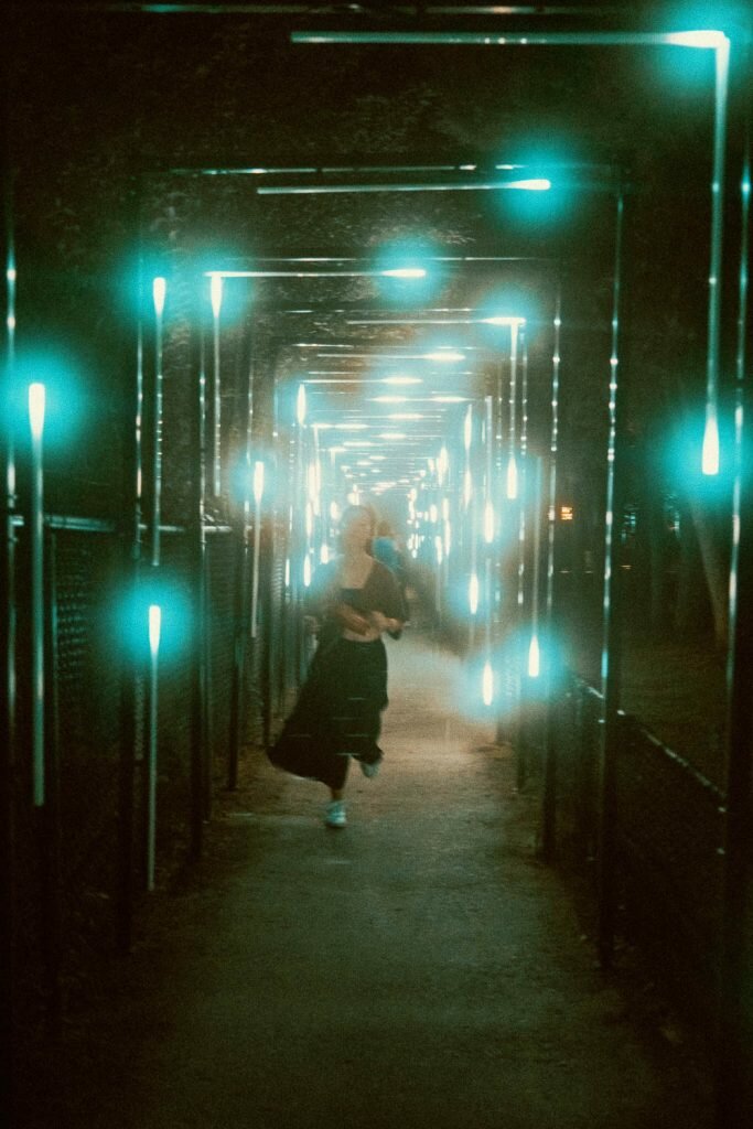 Woman running towards camera while staggered light arches frames the picture at the Terra Lumina event at the Toronto Zoo